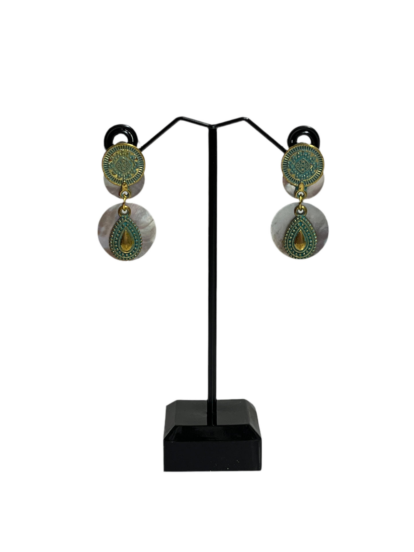 Pair of earrings on a black stand against a white background