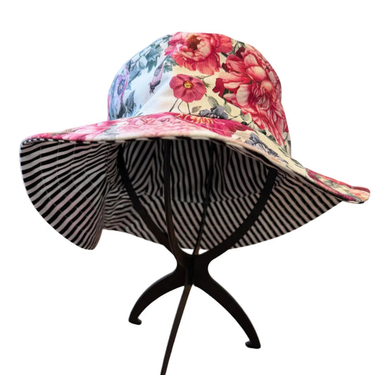 Floral stripe bucket hat on a black stand with a blurred indoor background