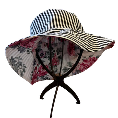 Striped sun hat with floral lining on a stand in a home setting
