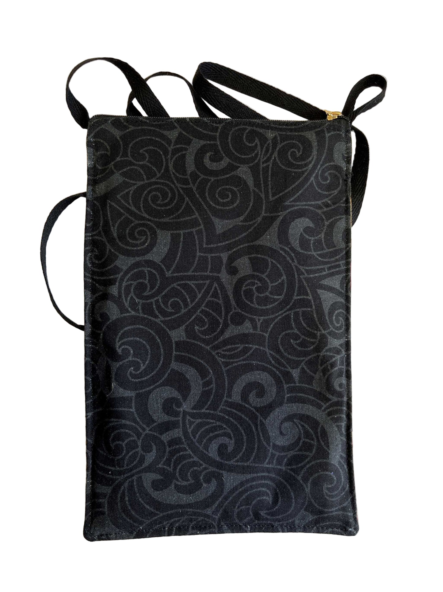 Back of mobile phone bag showing hand-sewn Kiwiana fabric with kererū, pōhutukawa flowers, tuatara, and Māori-inspired designs.