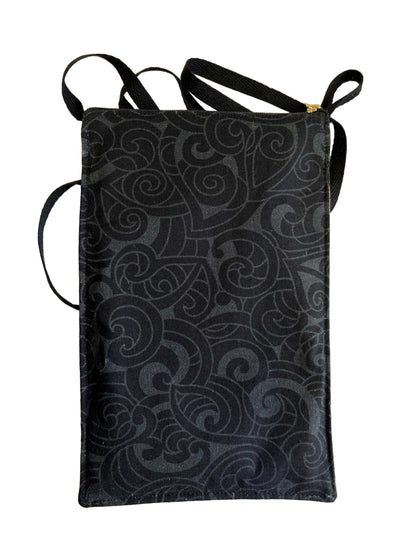 Back of mobile phone bag showing hand-sewn Kiwiana fabric with kererū, pōhutukawa flowers, tuatara, and Māori-inspired designs.