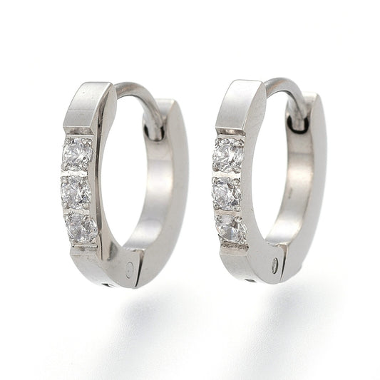 A pair of stainless steel huggie earrings with cubic zirconia accents.