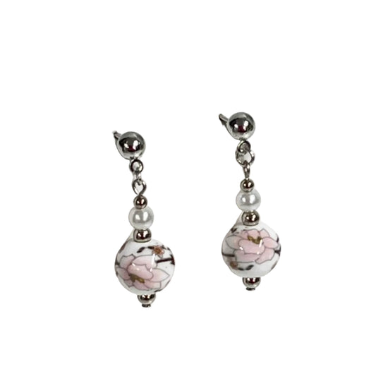 Pair of earrings with floral design on a white ceramic beads