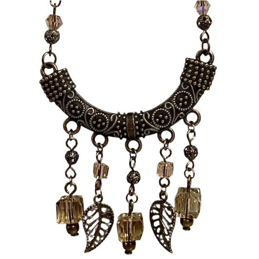 Decorative Bronze and Taupe necklace with intricate design and hanging beads on a white background