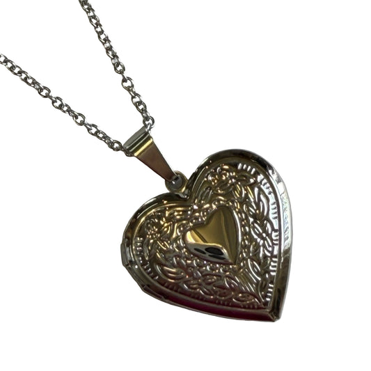 Silver heart-shaped locket with intricate designs on a chain