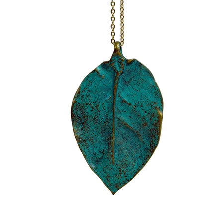 Teal leaf-shaped pendant on a gold chain against a white background