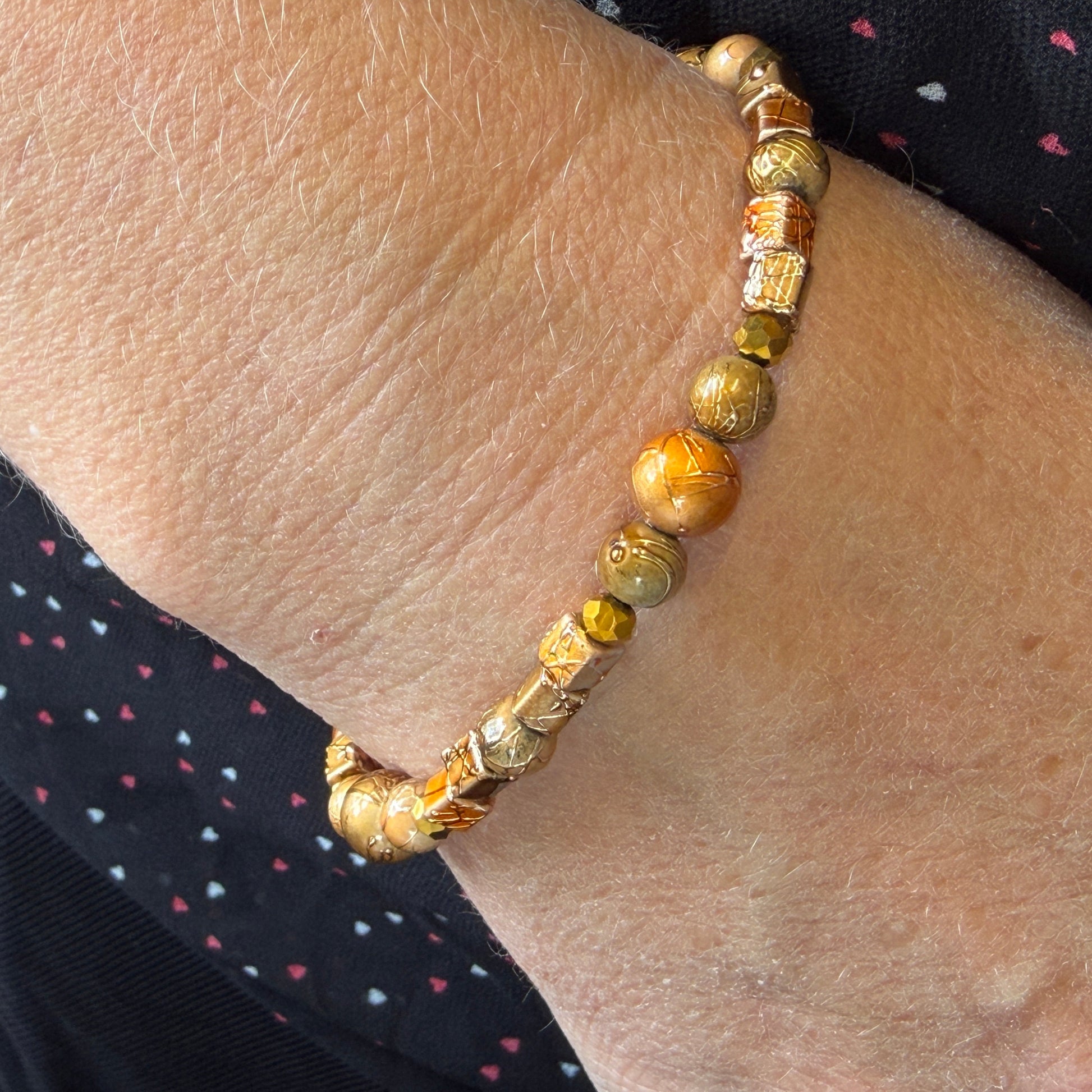 Gold and bronze beaded bracelet on a wrist