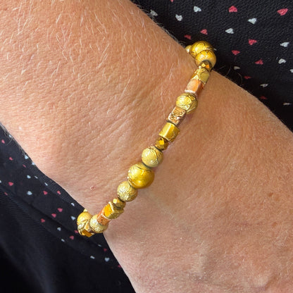 Gold beaded bracelet on a wrist