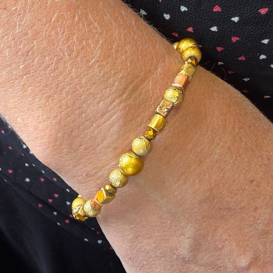 Gold beaded bracelet on a wrist