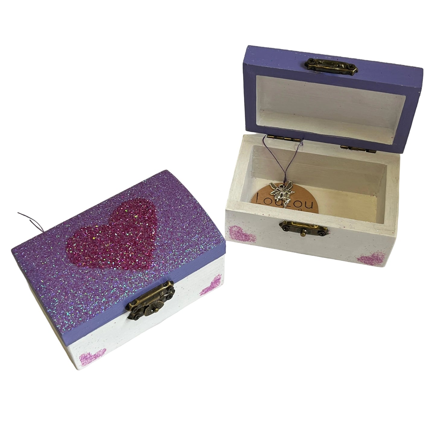 Two jewelry boxes, one purple with a heart design and the other open, on a white background.