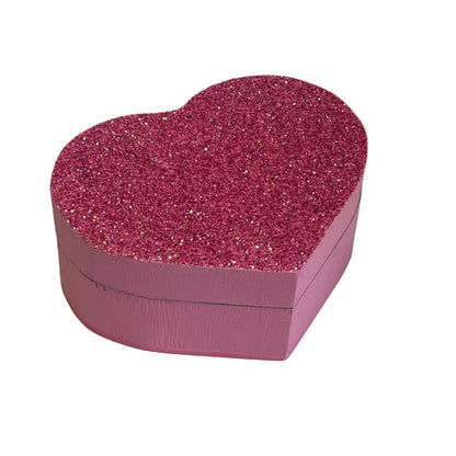Heart-shaped pink glittery box on a light background